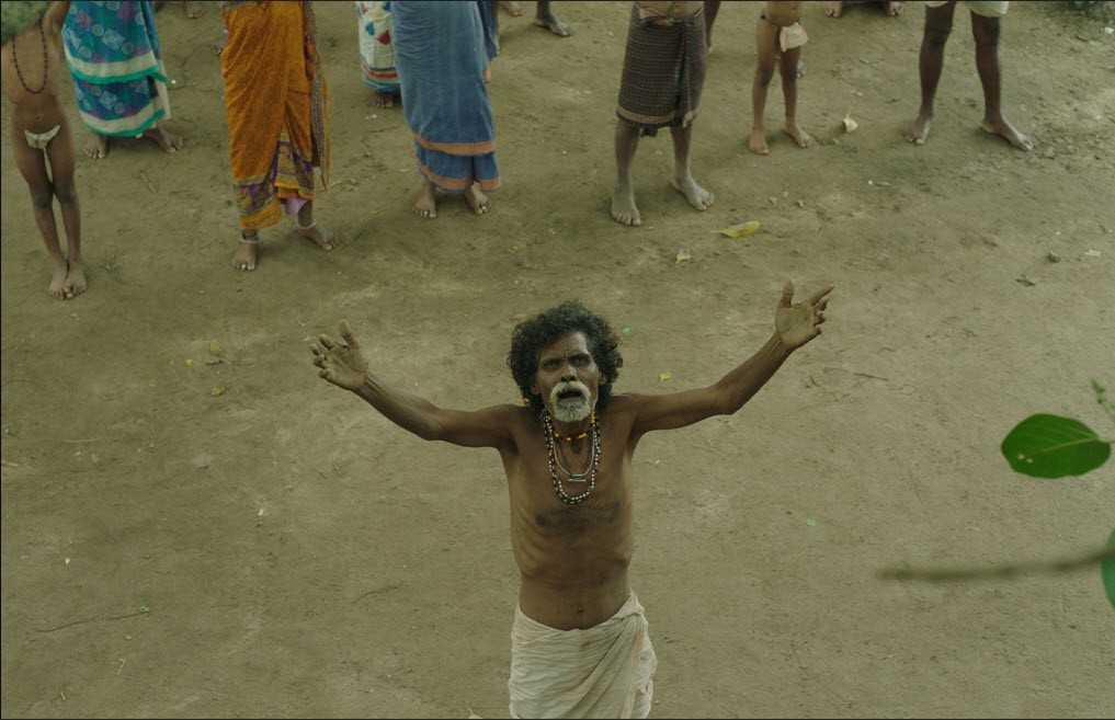 EGWA movie still showing the village chief praying with raised arms in a tribal village